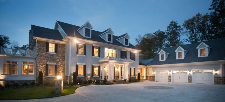 A custom home with lots of exterior lighting at dawn